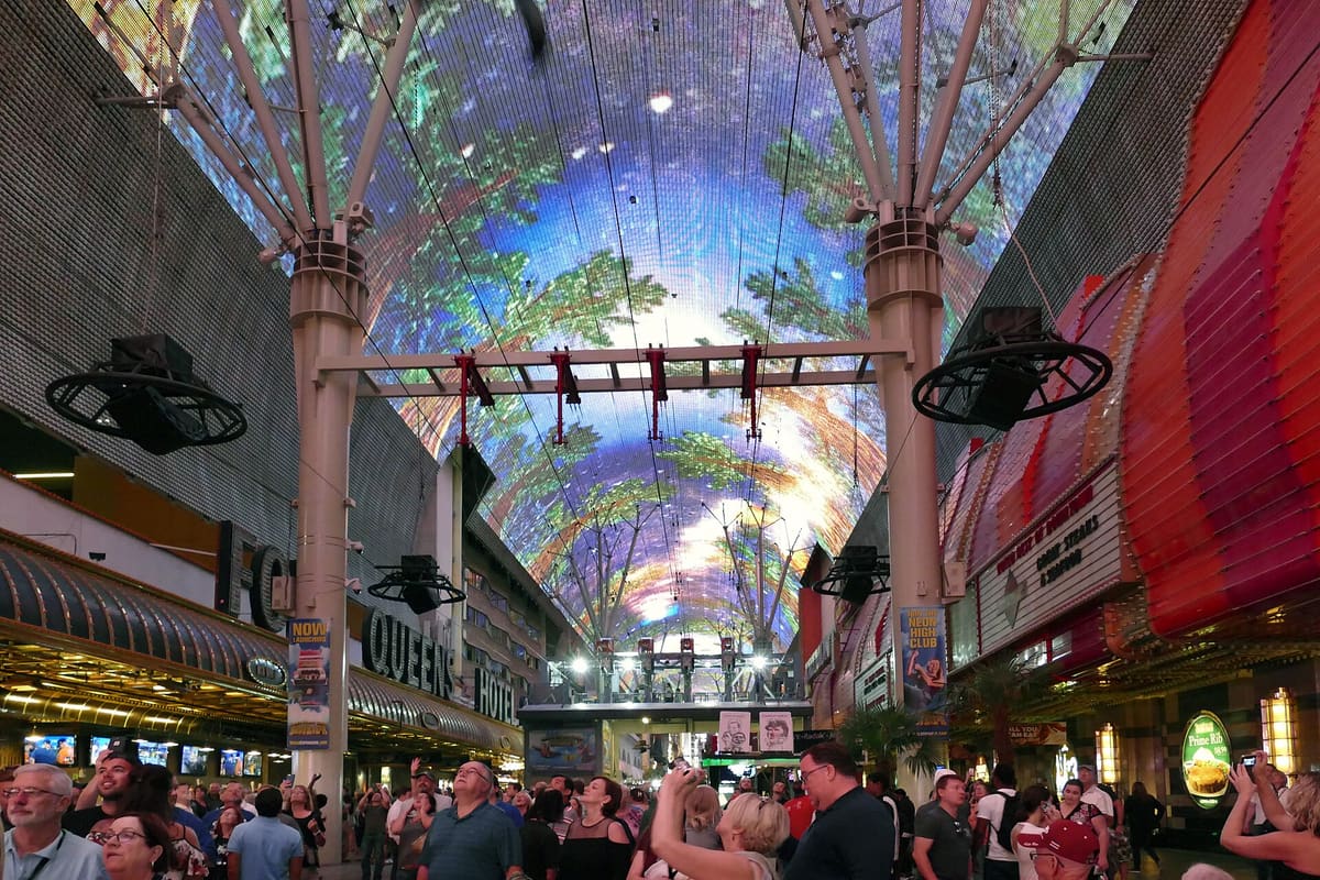 Curved LED canopy displaying imagery above a crowded pedestrian street